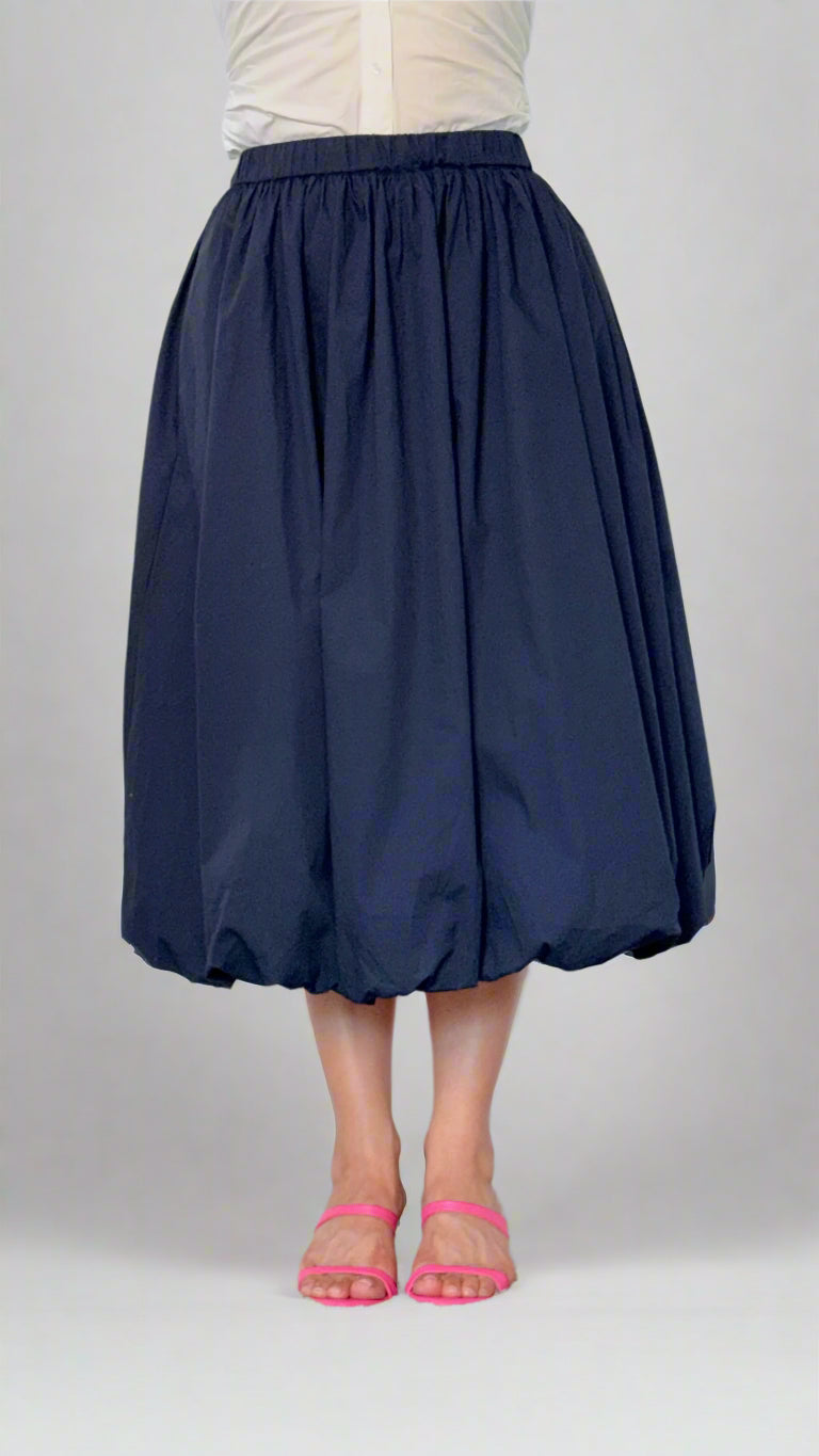 Navy blue skirt worn by a person on a plain background